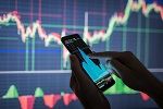 Ein Smartphone Nutzer vor einem Chart